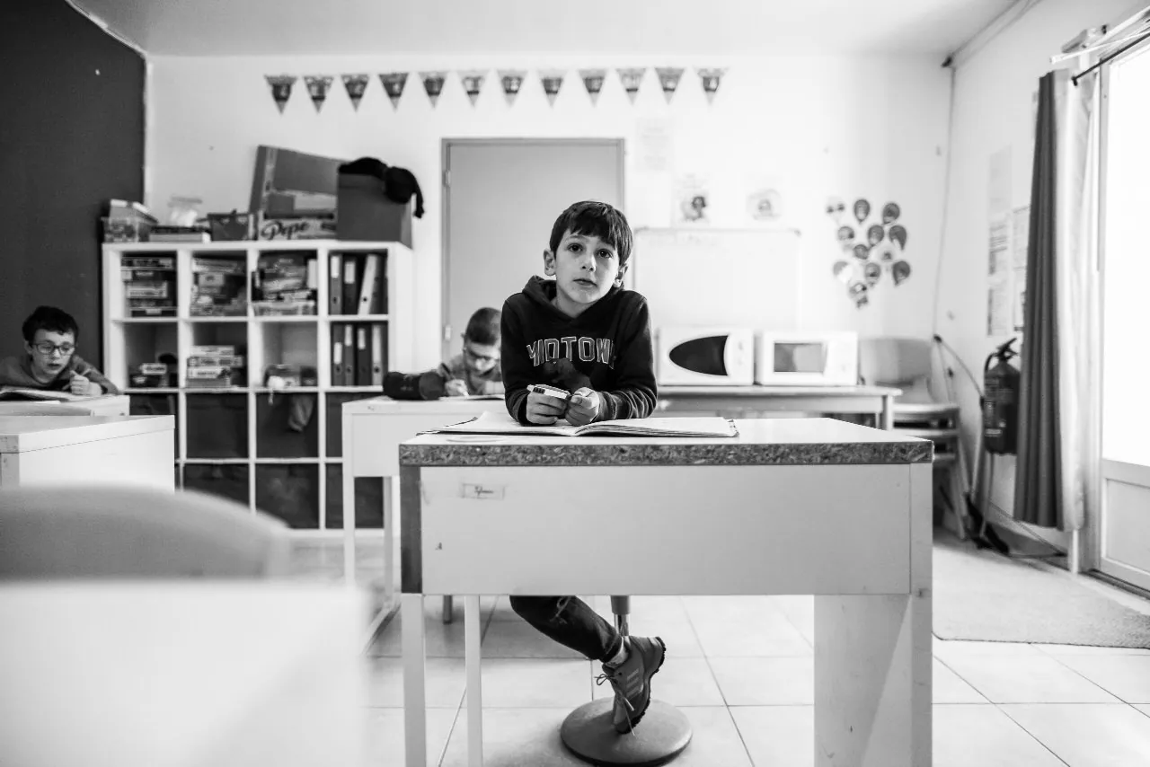 Au premier plan un élève à son bureau attentif à enseignement qui lui est délivré derriere lui 2 autres élève en train de prendre note, il fait bon apprendre à notre école galilée de saint Maximin - une école pour chacun