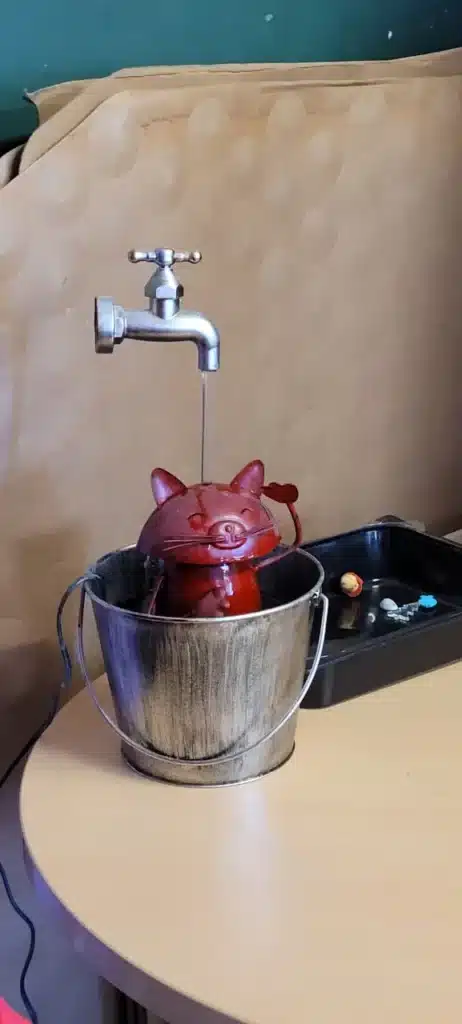 petit chat en métal qui prend une douche