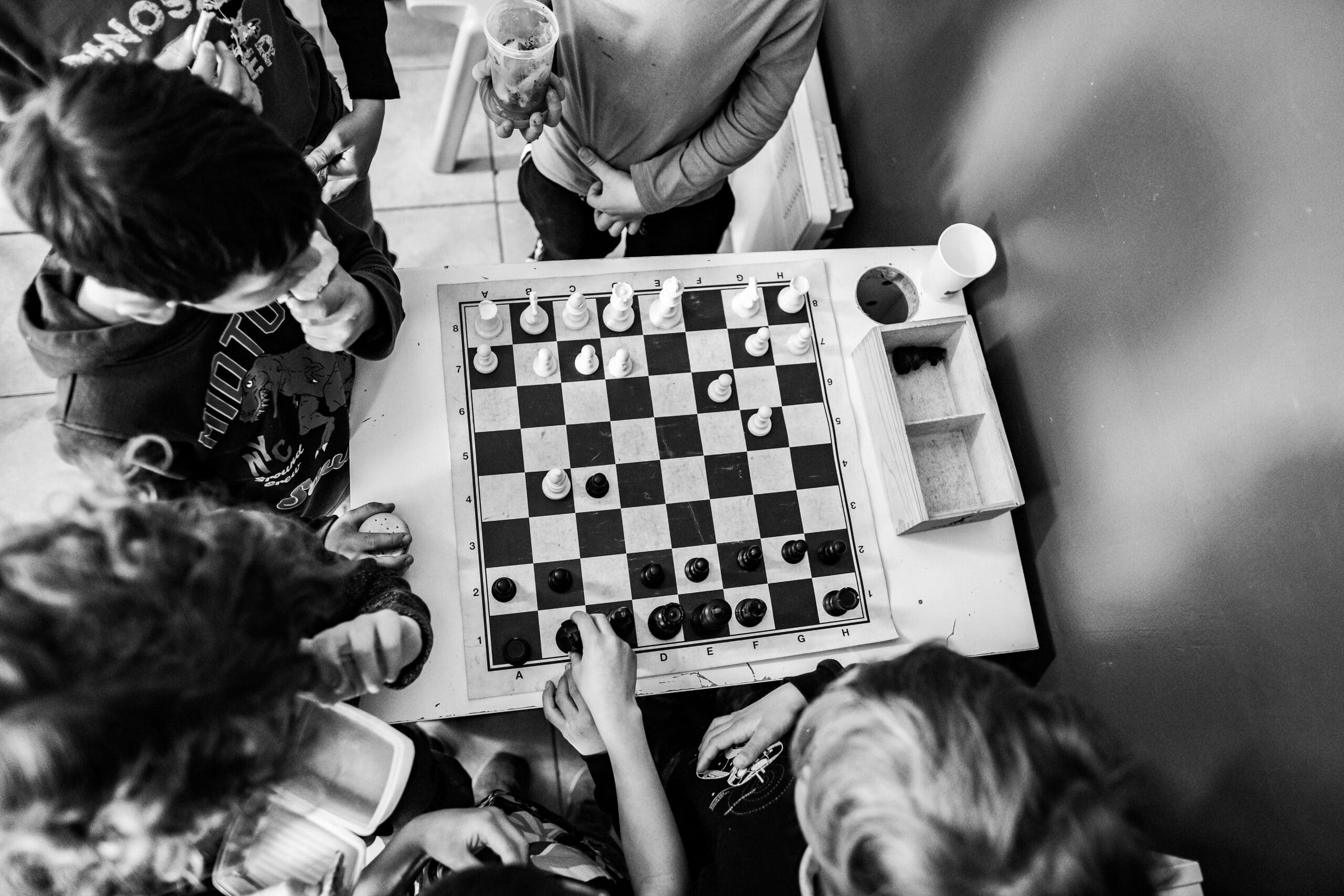 élèves de primaire autour d'un jeu d'échecs en train de réfléchir à la meilleure stratégie et les alternatives possibles